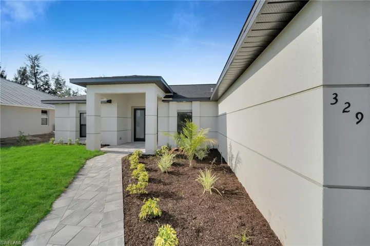 Doorway to property with stucco siding and a yard