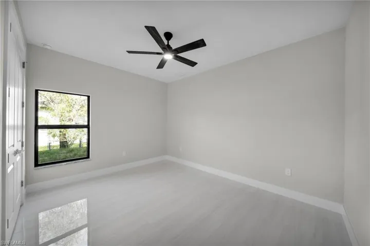 Unfurnished room with baseboards, a ceiling fan, and light wood-type flooring