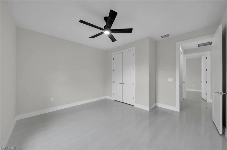 Unfurnished bedroom with a closet, baseboards, ceiling fan, and light wood finished floors
