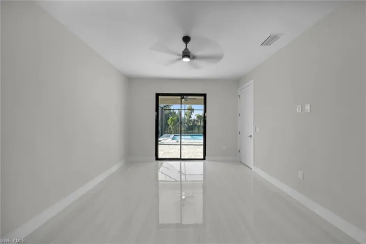 Empty room with a ceiling fan, baseboards, and light tile patterned floors