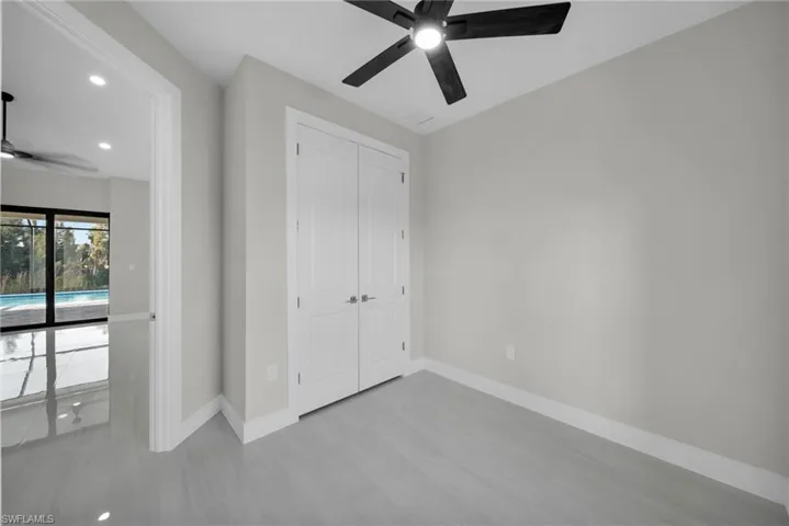 Unfurnished bedroom with baseboards, recessed lighting, a closet, a ceiling fan, and access to exterior