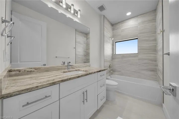 Bathroom featuring toilet,  shower combination, vanity, recessed lighting, and tile patterned floors