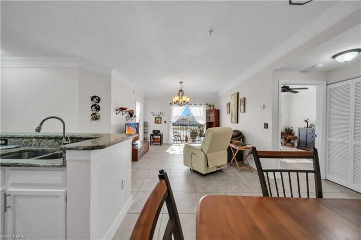 Dining area featuring suspended lighting, ornamental molding, ceiling fan, and light tile patterned flooring