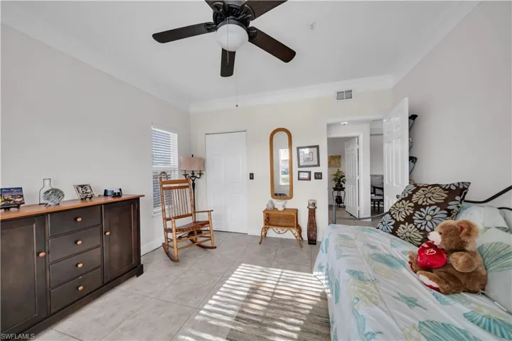 Bedroom featuring crown molding, a ceiling fan, and light tile patterned floors