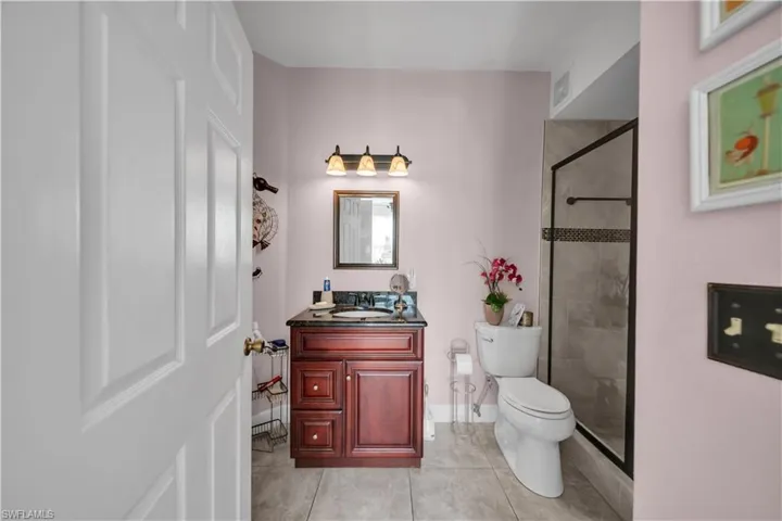 Full bath featuring vanity, a shower stall, and light tile patterned flooring