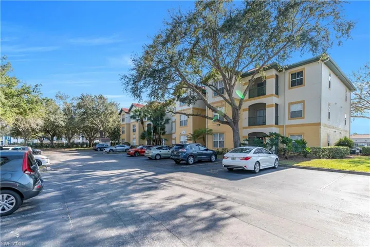 View of apartment building / complex with uncovered parking