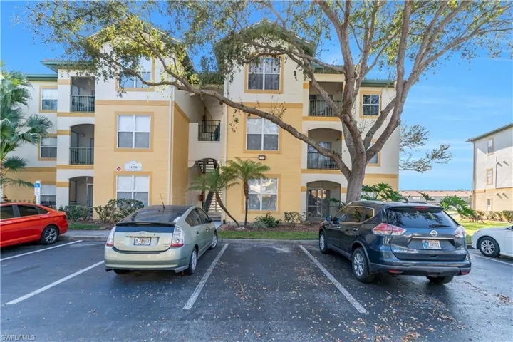 View of apartment building / complex with uncovered parking