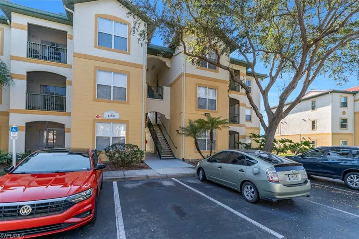 View of apartment building / complex with stairway and uncovered parking