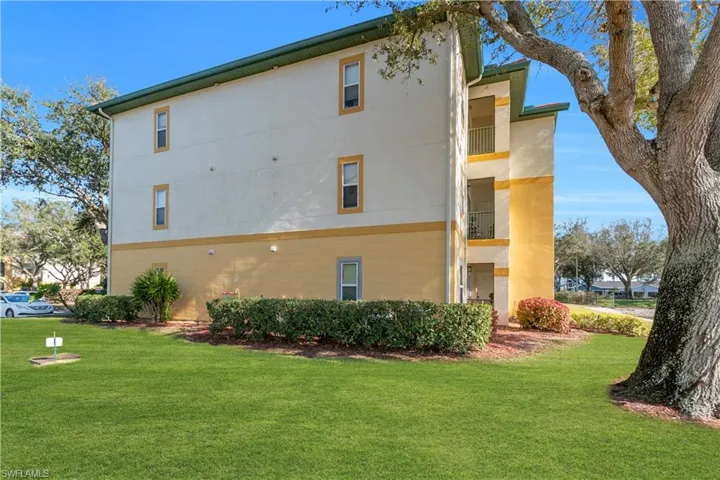 View of property exterior with a lawn and a balcony