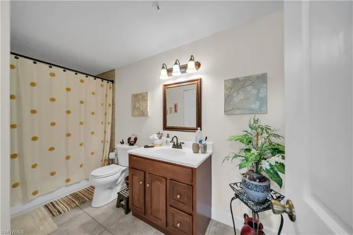 Full bathroom with vanity and light tile patterned floors