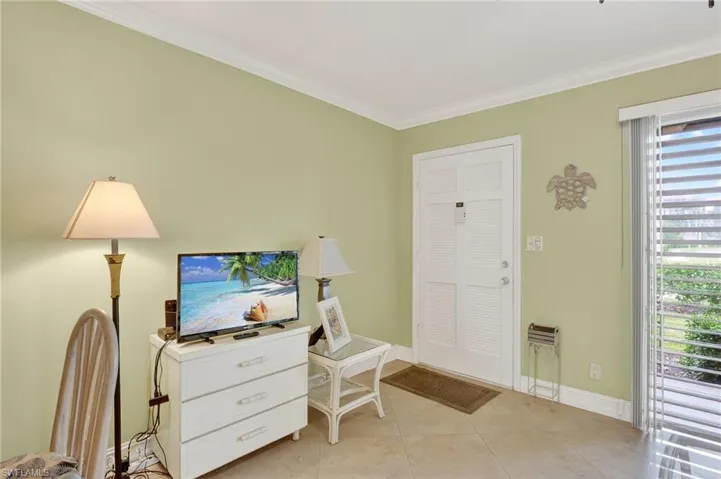Office area with crown molding and light tile patterned floors