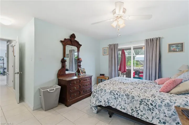Bedroom featuring access to exterior, ceiling fan, and light tile patterned flooring