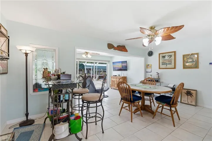Dining space with a ceiling fan and light tile patterned floors
