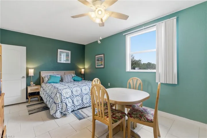Bedroom with ceiling fan and light tile patterned floors