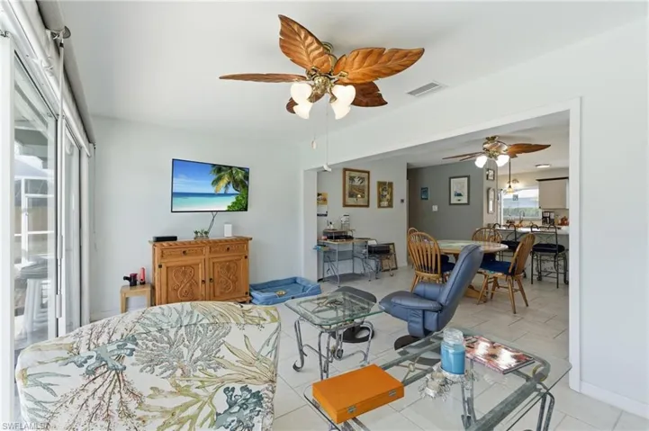 Living area with ceiling fan and light tile patterned floors
