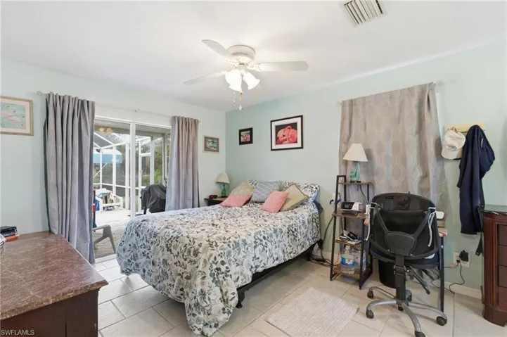 Bedroom featuring access to exterior, a desk, a ceiling fan, and light tile patterned floors