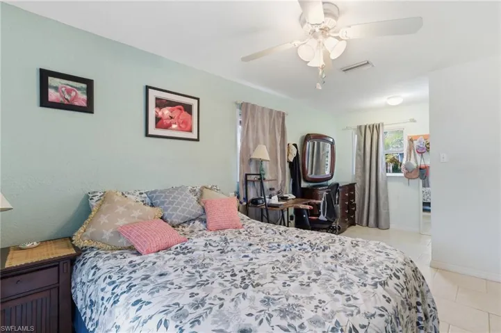Bedroom with light tile patterned floors and ceiling fan