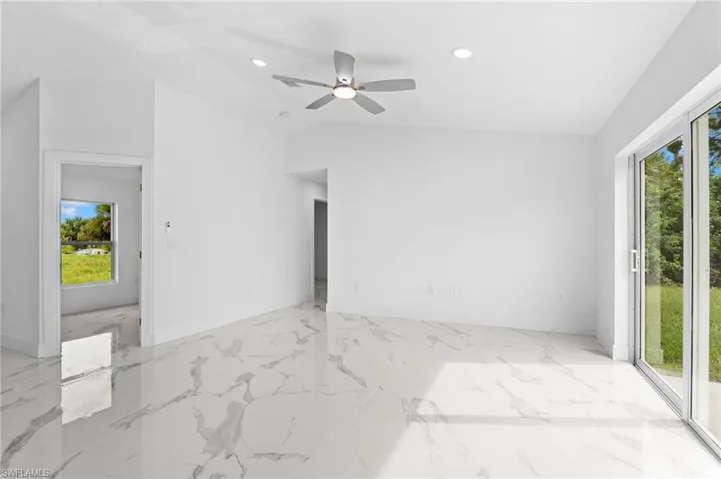 Empty room featuring lofted ceiling, recessed lighting, and ceiling fan