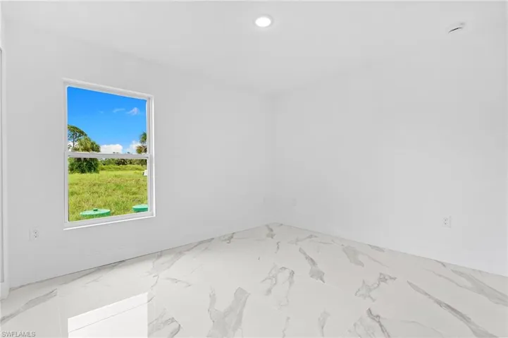 Unfurnished room with light marble finish floors and recessed lighting