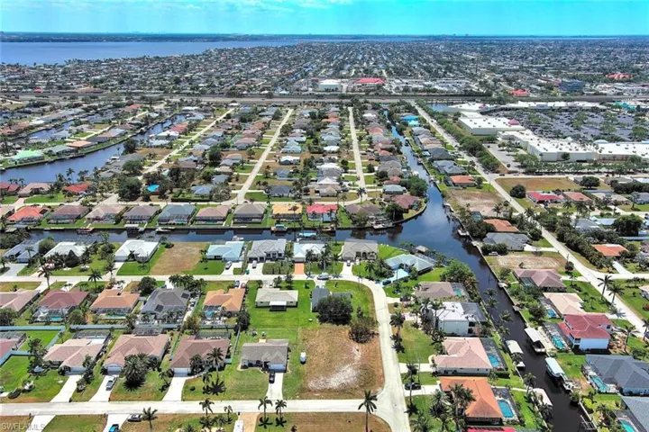 Aerial view of property and surrounding area with a large body of water and nearby suburban area