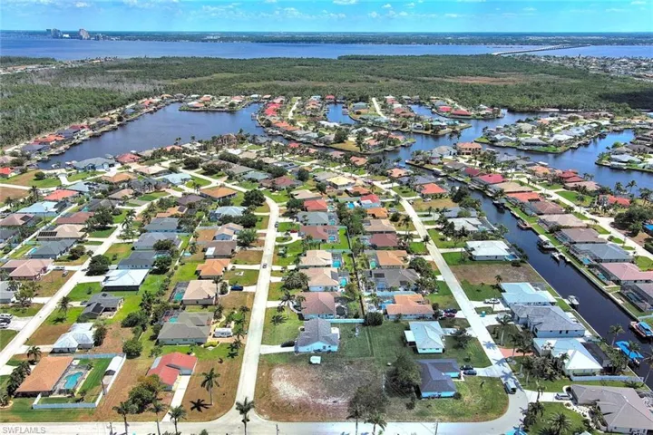 Aerial view of property's location with nearby suburban area and a nearby body of water