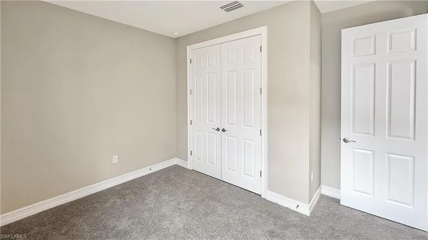 Unfurnished bedroom featuring a closet and carpet floors