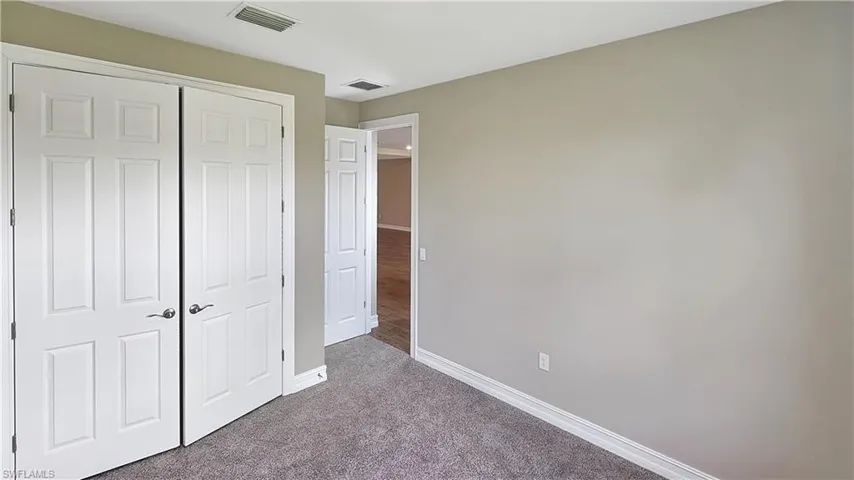 Unfurnished bedroom with a closet and carpet floors