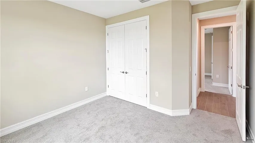 Unfurnished bedroom featuring a closet and light colored carpet