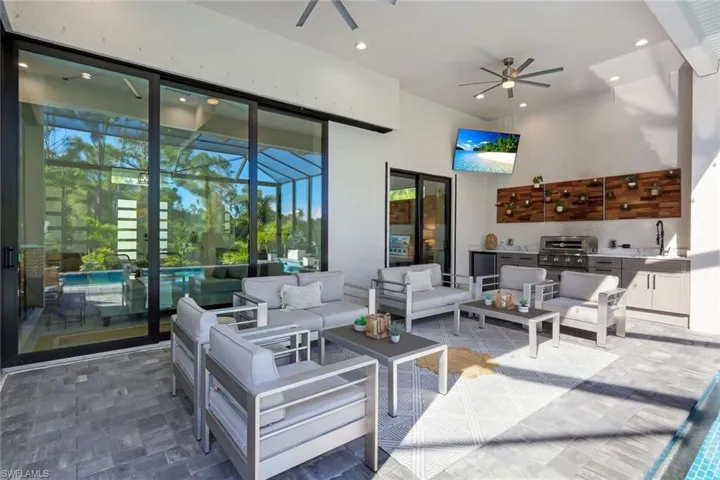 View of patio with area for grilling, an outdoor living space, sink, and ceiling fan