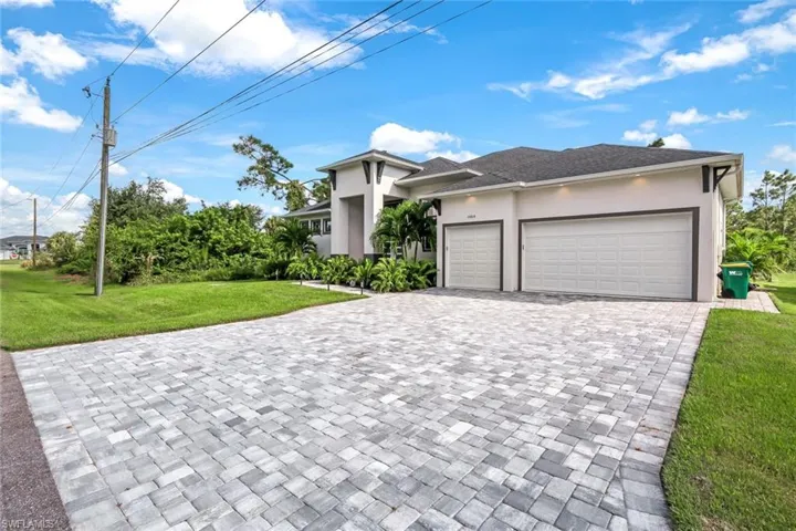 View of front facade featuring a front yard and a garage