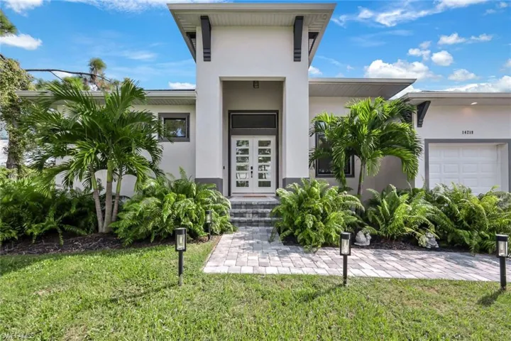 Property entrance with a yard and a garage