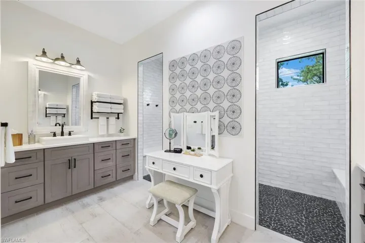 Bathroom featuring a tile shower and vanity