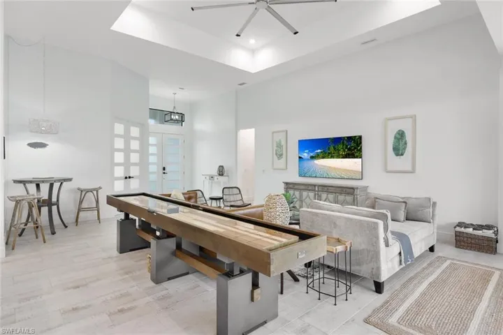 Recreation room featuring light wood-type flooring, a high ceiling, and ceiling fan