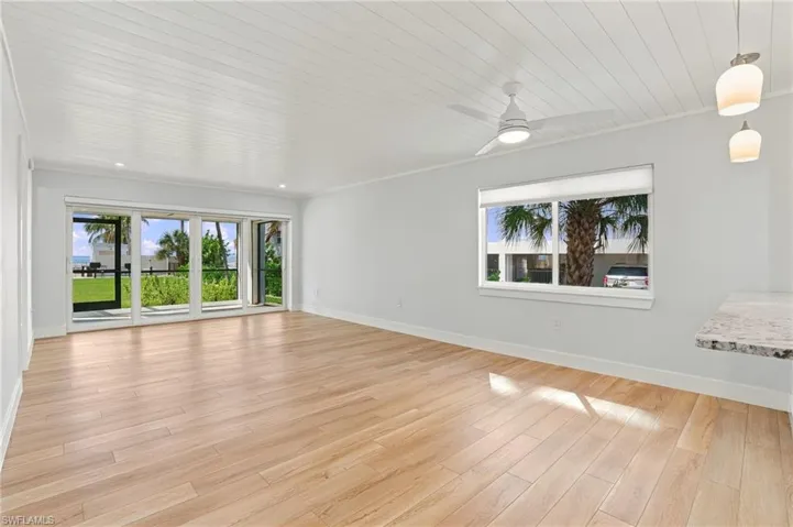 Open living area with beautiful tile flooring, fresh paint and Gulf views- Virtually Edited Image
