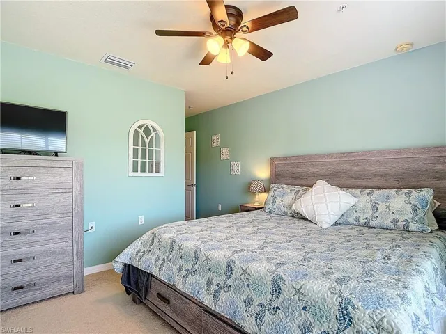 Bedroom with light colored carpet and ceiling fan