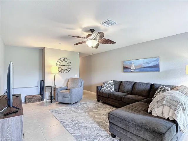 Living room with light tile patterned flooring and ceiling fan