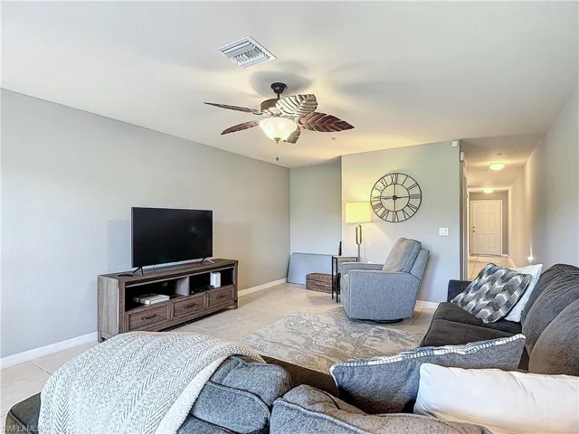 Living room with ceiling fan and light tile patterned floors