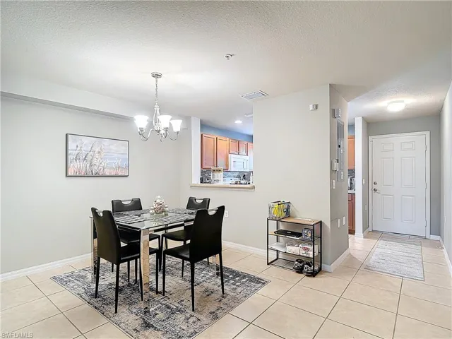 Tiled dining area with a chandelier and a textured ceiling