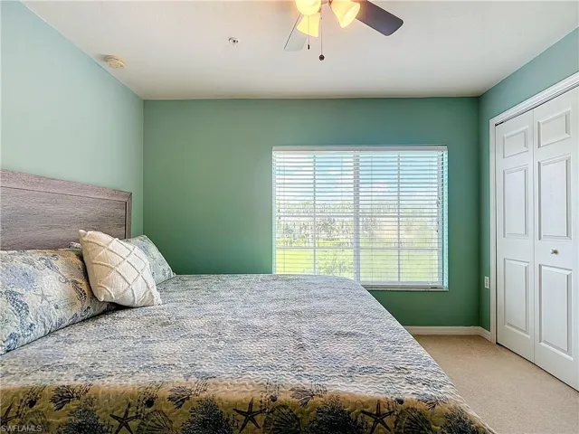 Carpeted bedroom featuring a closet and ceiling fan