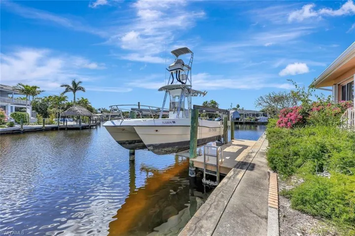 Dock area featuring boat lift and a water view