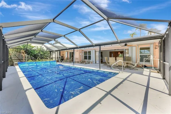 View of pool featuring a patio area, a covered pool, and glass enclosure