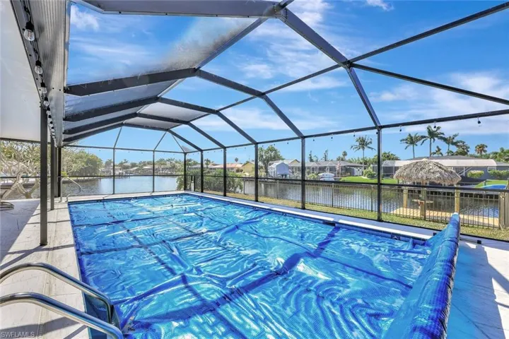 View of pool featuring a patio area, a covered pool, and a water view