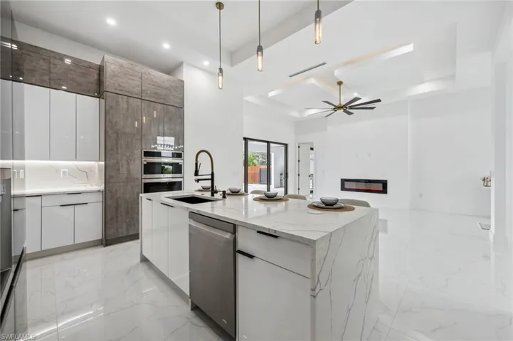 Kitchen with stainless steel appliances and custom cabinetry and quartz counters.