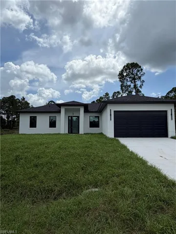 Contemporary exterior with a dark shingle roof, white stucco facade, and a black garage door