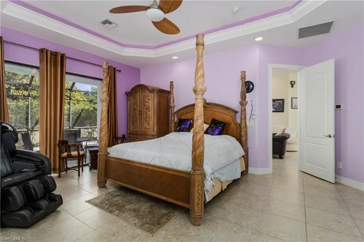 Bedroom featuring a tray ceiling, crown molding, access to outside, ceiling fan, and light tile patterned floors