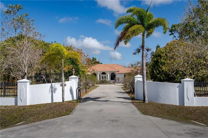Mediterranean / spanish house featuring a fenced front yard, a gate, and a chimney