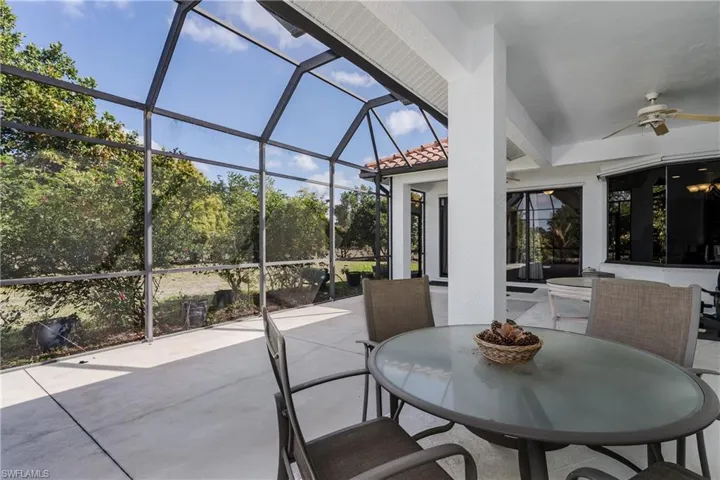 View of patio with a sunroom, ceiling fan, a lanai, and outdoor dining space