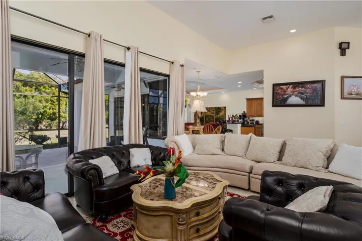 Living area featuring a chandelier, a ceiling fan, and a sunroom