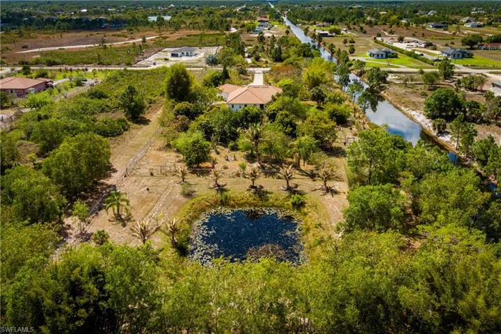 Drone / aerial view of a nearby body of water and a tree filled landscape