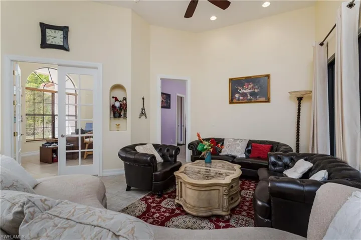 Living area featuring french doors, a high ceiling, ceiling fan, tile patterned flooring, and recessed lighting